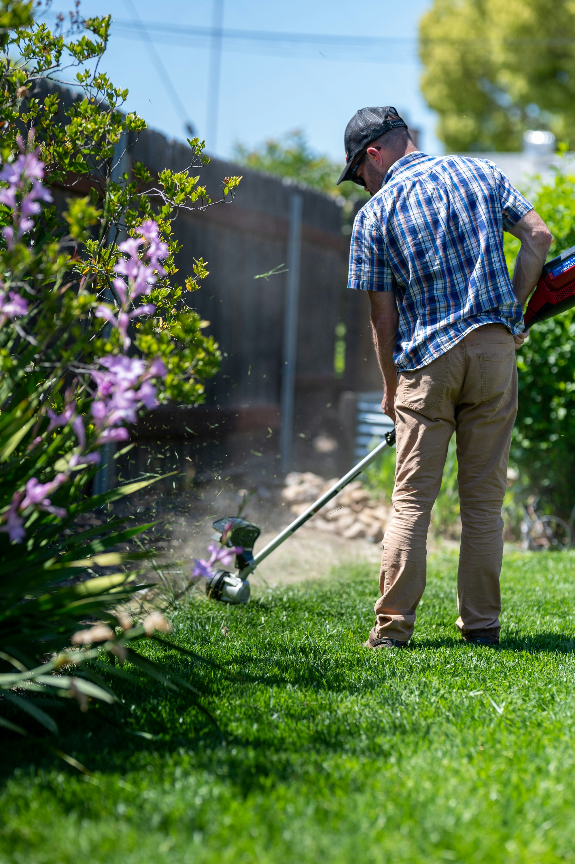 Landscaper trimming edges along a residential lawn